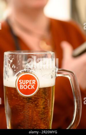 Lissabon, Portugal - 30. April 2023: Ein Tourist, der ein Super Bock Bier in einem Terrassenrestaurant genießt Stockfoto