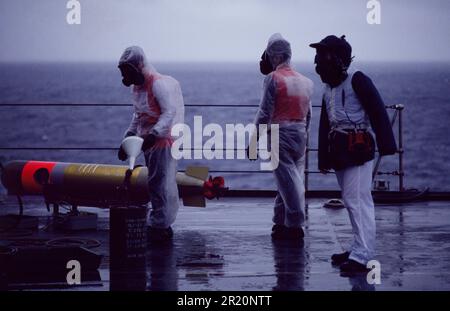 HMS Unbesiegbare Crew, Torpedoraketen an Deck vorbereiten, 1984 Stockfoto