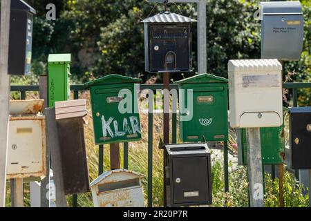 Verschiedene farbige Briefkästen am Straßenrand Stockfoto