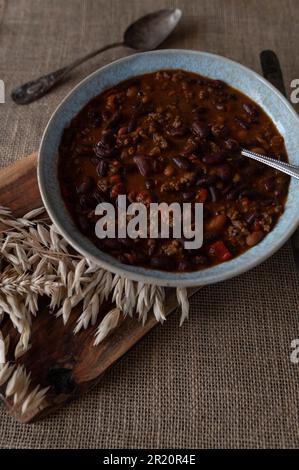 Eintopf mit gemahlenem Rindfleisch, gebackenen Bohnen, Paprika, Zwiebeln, Knoblauchkräuter, Tomaten auf einem Teller Stockfoto