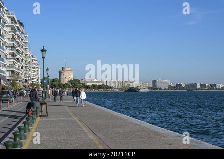 Thessaloniki, Griechenland, 28. April 2023: Strandpromenade am Mittelmeer mit Spaziergängern zum Weißen Turm, dem berühmten Wahrzeichen und Stockfoto