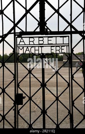 Foto des Slogans "Arbeit macht frei" am Eingang zum KZ Dachau. Der deutsche Ausdruck bedeutet „Arbeit macht Sie frei“. Das Lager war das erste der 1933 eröffneten Konzentrationslager der Nazis. Die ursprüngliche Absicht des Lagers bestand darin, politische Gefangene festzuhalten. Stockfoto