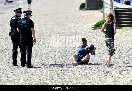 Foto der Polizei, die die Sperrregeln in Southend-on-Sea, Essex, durchsetzt, indem sie Sonnenanbeter auffordert zu gehen. Stockfoto