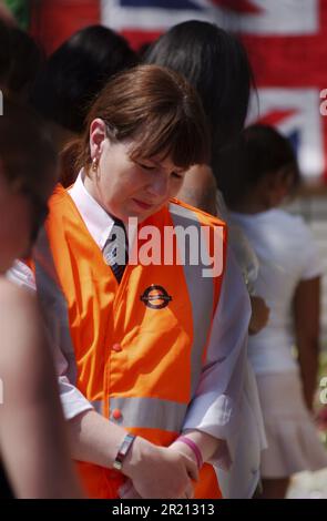 Foto eines Arbeiters der Londoner U-Bahn, der sich die Ehrungen für die Opfer des Terroranschlags von 7/7 vor der Station Kings Cross ansieht. Die Bombenanschläge vom 7. Juli 2005 in London, die oft als 7/7 bezeichnet werden, waren eine Reihe koordinierter islamistischer Selbstmordattentate in London, England, die auf Pendler abzielen, die während der Morgenstürme mit dem öffentlichen Nahverkehrssystem der Stadt unterwegs waren. Stockfoto