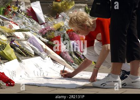 Foto von Mitgliedern des öffentlichen Platzes, die nach Londons Terroranschlägen in der Nähe des Tavistock Square geehrt und Blumen geehrt haben. Die Bombenanschläge vom 7. Juli 2005 in London, die oft als 7/7 bezeichnet werden, waren eine Reihe koordinierter islamistischer Selbstmordattentate in London, England, die auf Pendler abzielen, die während der Morgenstürme mit dem öffentlichen Nahverkehrssystem der Stadt unterwegs waren. Stockfoto