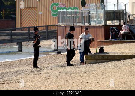 Foto der Polizei, die die Sperrregeln in Southend-on-Sea, Essex, durchsetzt, indem sie Sonnenanbeter auffordert zu gehen. Stockfoto