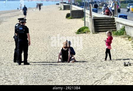 Foto der Polizei, die die Sperrregeln in Southend-on-Sea, Essex, durchsetzt, indem sie Sonnenanbeter auffordert zu gehen. Stockfoto