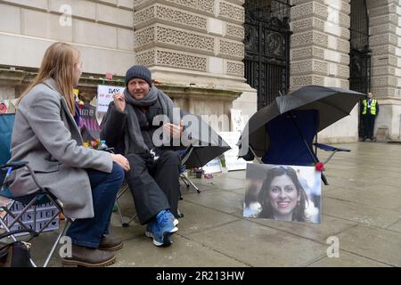 Ein Mitglied der Öffentlichkeit sitzt und plaudert mit Richard Ratcliffe, während er vor dem Auswärtigen Amt in London protestiert und die britische Regierung weiterhin drängt, Druck auf Iran auszuüben, damit seine Frau Nazanin Zaghari-Ratcliffe, eine iranisch-britische Doppelbürgerin, frei wird. Die seit 2016 von den iranischen Behörden in Haft genommen wird. Die Befürchtungen über Richard Ratcliffes Wohlergehen wuchsen, als sein Hungerstreik seinen 18. Tag erreichte. November 2021. Stockfoto