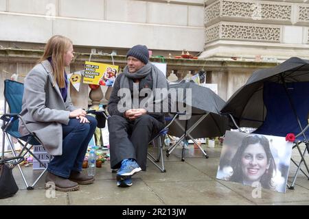 Ein Mitglied der Öffentlichkeit sitzt und plaudert mit Richard Ratcliffe, während er vor dem Auswärtigen Amt in London protestiert und die britische Regierung weiterhin drängt, Druck auf Iran auszuüben, damit seine Frau Nazanin Zaghari-Ratcliffe, eine iranisch-britische Doppelbürgerin, frei wird. Die seit 2016 von den iranischen Behörden in Haft genommen wird. Die Befürchtungen über Richard Ratcliffes Wohlergehen wuchsen, als sein Hungerstreik seinen 18. Tag erreichte. November 2021. Stockfoto