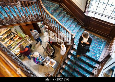 Hölzerne Treppe im georgianischen Stil mit blauem Teppich mit Blumenmuster in der William Morris Gallery, Walthamstow, London, Großbritannien Stockfoto