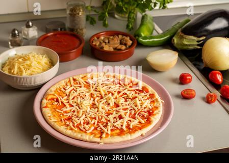 Zutaten für vegetarische Pizza zu Hause, mit Käse für Veganer und Gemüse. Stockfoto