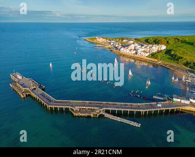 Swanage, Dorset, Vereinigtes Königreich. Swanage Bay, wo die Flut um die Piers rollt. Luftbild. 11. Mai 2023 Stockfoto