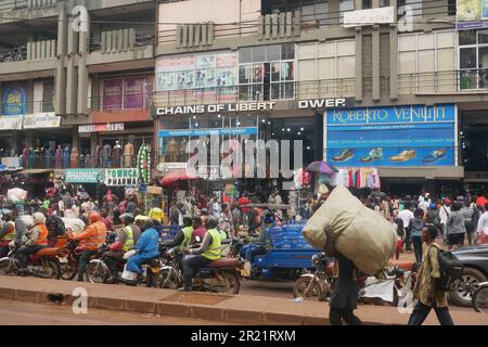 Verkehr und Fußgänger in einer belebten Straße im Zentrum von Kampala Stockfoto