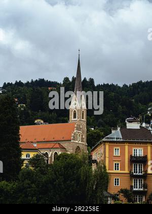 Ziegelmauern katholische Kirche St. Nikolaus in Innsbruck, Tirol, Österreich, bewölkter Himmel im Sommer Stockfoto