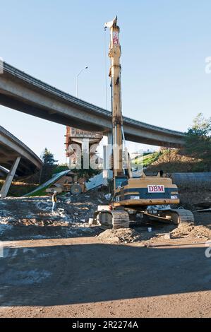 Ein Bohrfahrzeug zum Graben von Bohrschächten zur Unterstützung von Autobahnrampen und -abfahrten. Stockfoto