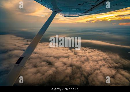 Luftaufnahme des farbenfrohen Himmels bei Sonnenuntergang, von einem einmotorigen Flugzeug aus gesehen, Stockfoto