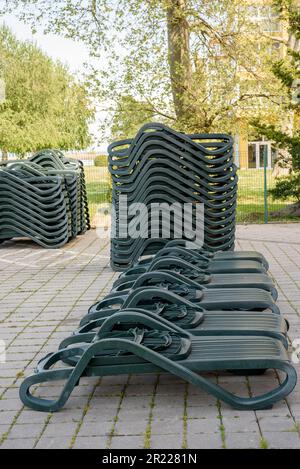 Ein Stapel grauer Liegestühle. Liegestühle am Strand. Stockfoto