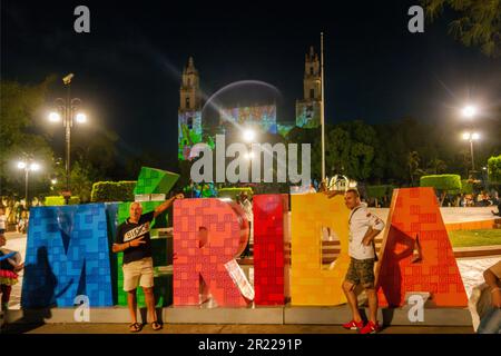 Männer posieren für ein Foto vor dem MERIDA-Schild vor der Kathedrale von Merida San Ildefonso Yucatan Mexico Stockfoto