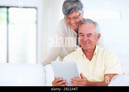 Ältere Ehepaare, die einen Tablet-PC verwenden. Glückliches, reifes Paar, das zu Hause einen Tablet-PC nutzt. Stockfoto