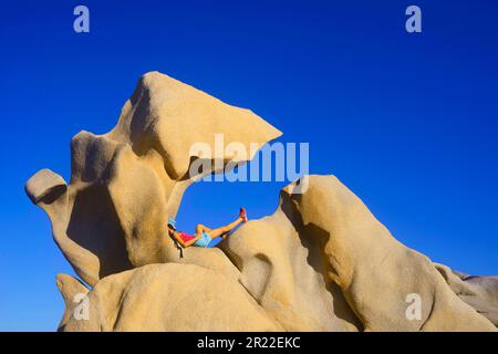 Tourist liegt auf einem Felsen in der Nähe von Campomoro, Frankreich, Korsika, Campomoro Stockfoto