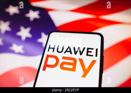 In dieser Fotoabbildung wird das Huawei Pay-Logo auf einem Smartphone-Bildschirm und im Hintergrund die Flagge der Vereinigten Staaten von Amerika angezeigt. Stockfoto