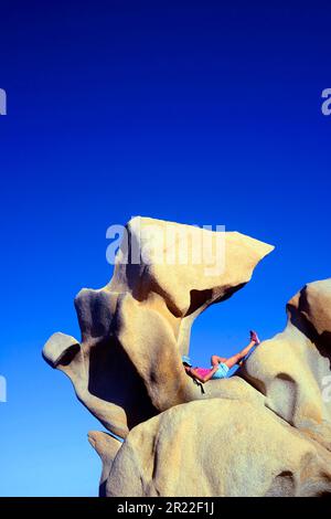 Tourist liegt auf einem Felsen in der Nähe von Campomoro, Frankreich, Korsika, Campomoro Stockfoto