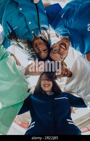 Gruppe von Ärzten eine medizinische Krankenschwester und ein Chirurg werden in einer herzlichen Umarmung gefangen und zeigen ihre Einheit, Teamarbeit und tiefe Verbindung in der Stockfoto