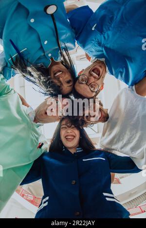 Gruppe von Ärzten eine medizinische Krankenschwester und ein Chirurg werden in einer herzlichen Umarmung gefangen und zeigen ihre Einheit, Teamarbeit und tiefe Verbindung in der Stockfoto