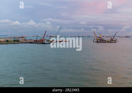 Boote und Bagger in der Nähe des Yachthafens in Singapur Stockfoto