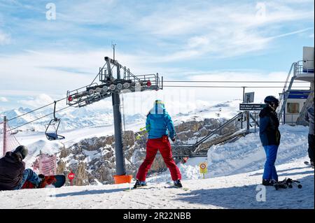 Rette und unterstütze die Skifahrerin, die sich auf den Abstieg vom Gipfel vorbereitet. Personal des Skigebiets in Les Diablerets, Glacier 3000. Stockfoto