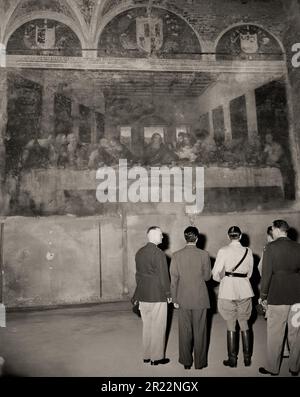 1945 , 25 . juni , MAILAND , ITALIEN : an den letzten Tagen des Zweiten Weltkriegs . Amerikanische und britische Offiziere sehen LEONARDO Da VINCIS Meisterwerk "das letzte Abendmahl " ( L'ULTIMA CENA ) in der Kirche Santa Maria delle Grazie in Mailand . Vom Krieg verschont und unbeschädigt. Wie durch ein Wunder überlebte man einen Bombenanschlag der Alliierten (nur die Mauer mit dem Fresko blieb in den Trümmern unversehrt, während das gesamte Kloster der Madonna delle Grazie zu Boden gerissen wurde). Leonardo da Vincis berühmtes Fresko wird vom britischen Feldmarschall Sir HAROLD R.L.G. bewundert ALEXANDER ( trägt Sam Browne Gürtel - Rupert Leofric George, 189 Stockfoto