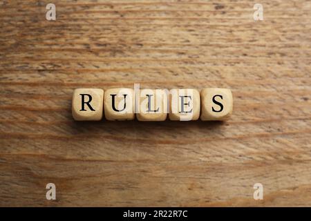 Wortregeln aus Würfeln mit Buchstaben auf einem Holztisch, Draufsicht Stockfoto