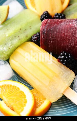 Köstliches Eis am Stiel, Eiswürfel und frisches Obst auf dem Teller, Nahaufnahme Stockfoto