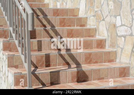 Wunderschöne geflieste Treppen mit Metallgeländern im Freien Stockfoto