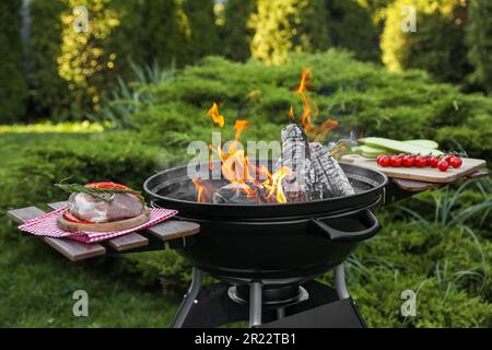 Rohes Fleisch und Gemüse auf dem Tisch neben dem Grill im Freien Stockfoto