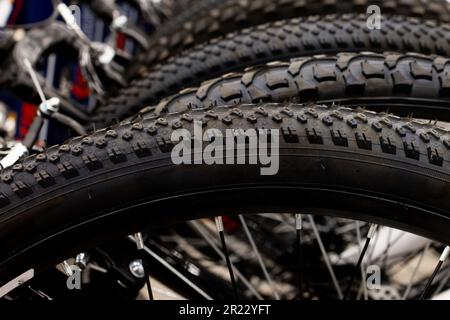 Im Store wird ein neues Sortiment an Fahrradreifen gelagert, ein Stapel schwarzer Reifen. Stockfoto