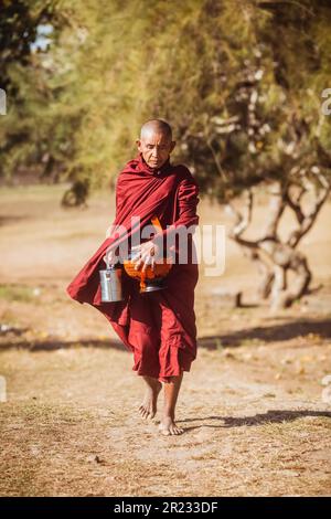BAGAN, MYANMAR - 02. APRIL 2018: Der buddhistische Anfängermönch Myanmar läuft auf der Straße vor der Thatbyinnyu-Pagode in Bagan. Stockfoto