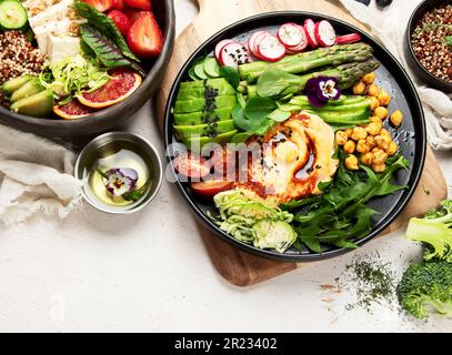 Gesunde vegetarische und vegane Salate und Buddha-Schalen mit Vitaminen, Antioxidantien, Proteinen auf hellem Hintergrund. Draufsicht, Kopierbereich Stockfoto