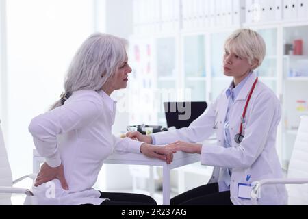 Ältere Klientin klagt über Schmerzen in den Nieren beim Arzt Stockfoto