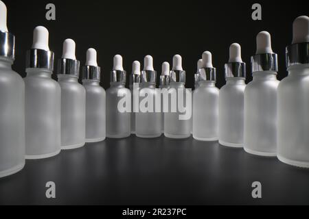 Große Anzahl leerer Flaschen mit Pipetten stehen im Kreis Stockfoto