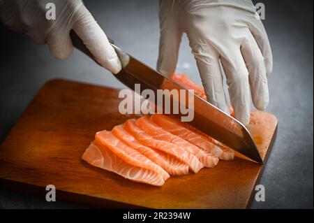 Lachsfilet auf Holzbrett, frisches rohes Lachsfilet mit Küchenmesser zum Kochen von Meeresfrüchten, Lachsfisch Stockfoto
