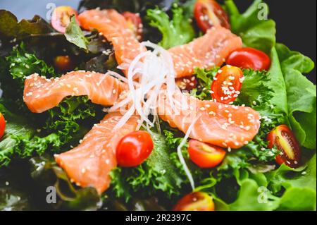 Lachs Salat Essen Lachs Filet mit Gemüsesalat Blatt Tomatenkraut und Gewürzen, frischer roher Lachs Fisch zum Kochen Lebensmittel Meeresfrüchte Lachs Fisch gesund Stockfoto