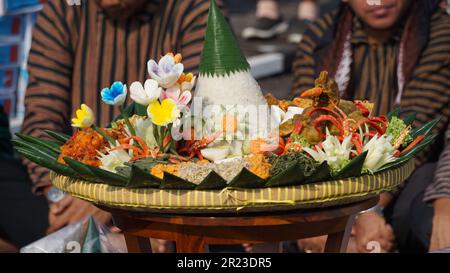 Nasi Tumpeng (Konusreis) serviert mit Urap-Uap (indonesischer Salat), gebratenem Hähnchen und Nudeln. Nasi-Tumpeng wird normalerweise auf Geburtstagspartys serviert Stockfoto