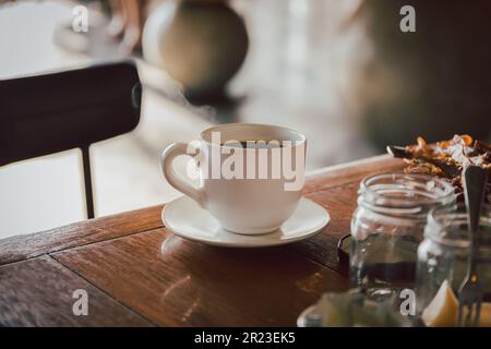 Eine Tasse schwarzen Kaffee auf dem Frühstückstisch am Morgen. Stockfoto