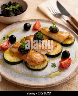 Gegrillter weißer Fisch mit Gemüse. Stockfoto