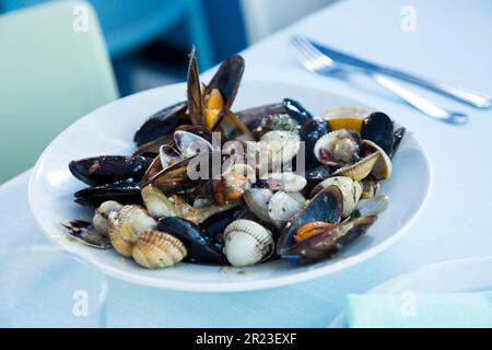 Gericht mit einer Vielzahl von Meeresfrüchten wie Muscheln, Muscheln und Meeresschnecken. Spanische Fisch-Tapa. Stockfoto