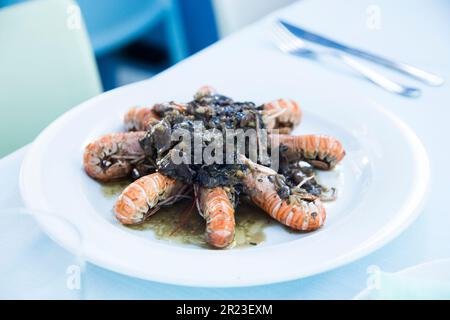 Im Ofen gekochte Scampi-Garnelen mit Petersilie und Knoblauch. Stockfoto