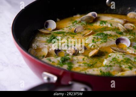 Blauer Wittling mit grüner Sauce. Traditionelles Rezept aus dem Baskenland in Nordspanien. Stockfoto