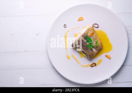 Bacalao al pil pil traditionelle Tapa aus Nordspanien. Kabeljau gekocht mit einer köstlichen Sauce aus Öl, Kabeljau und Knoblauch. Stockfoto