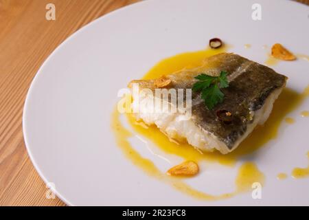 Bacalao al pil pil traditionelle Tapa aus Nordspanien. Kabeljau gekocht mit einer köstlichen Sauce aus Öl, Kabeljau und Knoblauch. Stockfoto